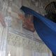 Foto: die Restituta-Büste von Hrdlicka wird enthüllt. Sie hängt an der Wand in der Kapelle, ein dunkelblaues Tuch, das sie verdeckt, hebt sich, Ansicht von unten